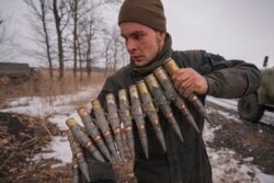 Un militar ucraniano lleva municiones de gran calibre durante un ejercicio en un área controlada por la Operación de Fuerzas Conjuntas en la región de Donetsk, este de Ucrania, el 10 de febrero de 2022.