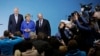 German Chancellor Angela Merkel is flanked by Bavarian governor Horst Seehofer (L) and Social Democratic Party Chairman Martin Schulz as they pose for a photo after the exploratory talks between Merkel's Christian Democratic block and the Social Democrats on forming a new German government in Berlin, Germany, Jan. 12, 2018. 