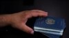 Beneficiario de una Visa Especial de Inmigrante (SIV) de EE.UU., tiene los pasaportes de su familia mientras firman un contrato de arrendamiento en un nuevo apartamento luego de su evacuación de Afganistán en Houston, Texas, EE. UU., 26 de agosto de 2021.