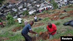Penggali kubur bekerja di pemakaman kota sementara kerabat dan teman menghadiri pemakaman Debora Listenberg, 22 dan anak-anaknya Heloise, 2 dan Gustavo, 5 setelah hujan lebat menyebabkan banjir di Petropolis, Brazil, 17 Februari 2022. (Foto: REUTERS/Ricardo Moraes)