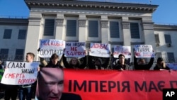 Manifestantes protestan con carteles frente a la embajada de Rusia en Kiev el 22 de febrero de 2022 a la decisión del Kremlin de reconocer a las regiones separatistas de Donbas y Luhansk.