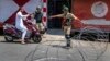 Indian paramilitary soldiers question a person on a scooter before letting him pass at a barbed-wire road checkpoint set up by Indian security forces in Srinagar, Indian-controlled Kashmir, July 7, 2017. 