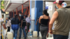Venezolanos hacen fila para llenar de agua sus bidones en Caracas. Foto Carolina Alcalde, VOA.