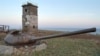 ARCHIVO - En esta foto sin fecha, una torreta de un viejo tanque enterrado como parte de las fortificaciones de guerra frente a un faro cerca de Yuzhno-Kurilsk en la isla Kunashiri, una de la cadena Kuril, conocida como los Territorios del Norte en Japón.