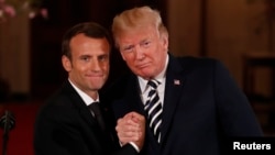 FILE - French President Emmanuel Macron clasps hands with U.S. President Donald Trump at the conclusion of their joint news conference in the East Room of the White House in Washington, U.S., April 24, 2018.