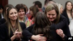 En esta foto del 24 de enero de 2018, las víctimas reaccionan y se abrazan con la fiscal adjunta Angela Povilaitis, luego que el doctor Larry Nassar fuera sentenciado a entre 40 y 175 años de prisión en Lansing, Michigan. 