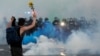 La policía avanza hacia un manifestante en Minneapolis, luego de un toque de queda el sábado 30 de mayo de 2020, al continuar las protestas por la muerte de George Floyd, un afroestadounidense a manos de la policía.