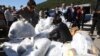 North Korean defectors carry plastic bags full of leaflets denouncing North Korea for canceling a planned reunion of Korean families, to be attached to balloons during an anti-North Korea rally near the Unification Observation Post in Paju, South Korea, O