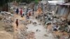 Somali people walk along a street after heavy rain storms hit the capital overnight, Mogadishu, June 8, 2018.