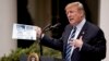 President Donald Trump holds up a stat sheet having to do with the Mueller Report as he speaks in the Rose Garden at the White House, May 22, 2019.