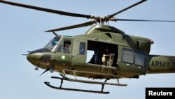 FILE - A Pakistani helicopter flies near the Baine Baba Ziarat mountain in Swat district, during a trip organized by the army May 22, 2009.