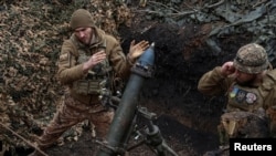 Військовослужбовці 28-ї окремої механізованої бригади стріляють із міномета у бік російських військ, поблизу міста Бахмут. 15 березня 2024 року. Фото REUTERS