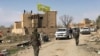 FILE - A Syrian Democratic Forces flag flutters on a damaged building in the town of Baghuz, Syria, March 23, 2019. 
