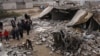 People inspect scene of car bombing in the predominantly ethnic Shabak village of al-Mouafaqiyah, near Mosul, Iraq, Dec. 17, 2012.