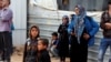 FILE - Syrian refugees are seen gathered for a news conference by visiting U.N. High Commissioner for Refugees Filippo Grandi (not pictured), at the Al Zaatari refugee camp, in the Jordanian city of Mafraq, near the border with Syria, Feb. 12, 2018.