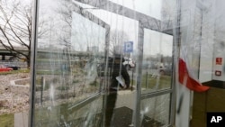 Police gather evidence after unknown perpetrators broke windows at the Muslim Cultural Center in Warsaw, Poland, Nov. 27, 2017. 