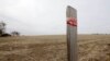 FILE - A stake in the ground wrapped with tape marks the route of the Keystone XL pipeline in Tilden, Nebraska, March 2014.