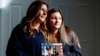 Pamela Yarosz and her daughter Capri are shown with a photo of New York firefighter Christopher Michael Mozzillo, Sept. 7, 2024, in Freehold, N.J.. Mozzillo, who died in the 9/11 attacks, was Pamela's brother. 