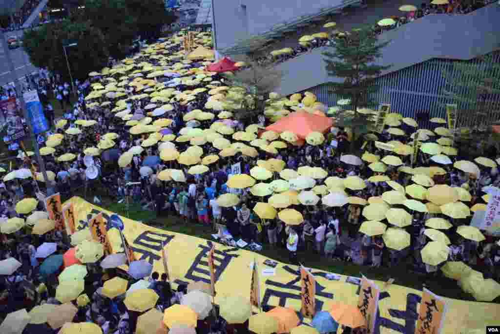 接近1,000名集會人士高舉黃傘默站,紀念香港警察去年向示威者施放催淚彈。(美國之音特約記者湯惠芸照)