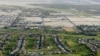 FILE - This aerial file photo shows lush green golf courses bordering the edge of the desert in Palm Springs, California, April 3, 2015. 