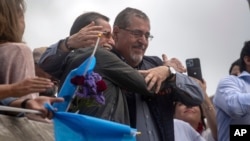 El presidente electo de Guatemala, Bernardo Arévalo, hijo del primer presidente elegido democráticamente en 1945, Juan José Arévalo, a la derecha, asiste a una marcha en la Ciudad de Guatemala, el 20 de octubre de 2023. 