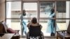 FILE - Relatives chat through a window to a wheelchair-bound woman, a resident of Casa Serena, a home for seniors, in Johannesburg, South Africa, July 22, 2020.