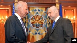 El vicepresidente Joseph Biden estrecha la mano del primer ministro en funciones de Ucrania, Oleksandr Turchynov.