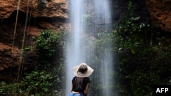 Un turista disfruta bajo una cascada durante la reapertura gradual del turismo en El Salvador, después de la cuarentena obligatoria para prevenir nuevas infecciones de COVID-19, en San Julián, Sonsonate, el 30 de septiembre de 2020.