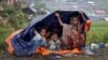 FILE - Rohingya refugees shelter from the rain in a camp in Cox's Bazar, Bangladesh, Sept. 17, 2017.