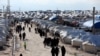 FILE - Women walk through al-Hol displacement camp in Hasaka governorate, Syria, April 1, 2019. There has long been worry about a potential coronavirus outbreak in northeastern Syria, home to several displaced-person and refugee camps.