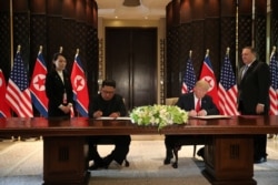 FILE - U.S. President Donald Trump and North Korea's leader Kim Jong Un sign documents that acknowledge the progress of the talks and pledge to keep momentum going, at the Capella Hotel on Sentosa island in Singapore, June 12, 2018.