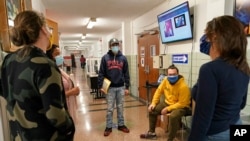 Estudiantes y personal docente de la Escuela Secundaria Comunitaria West Brooklyn, en Nueva York, conversan tras enterarse de que la escuela cerrará por tercera vez este año a causa del coronavirus, el 18 de noviembre de 2020.