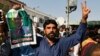 A supporter of former Pakistani Prime Minister Nawaz Sharif holds his picture and makes a victory sign after a court ruling, outside the Islamabad High Court in Islamabad, Pakistan, Sept. 19, 2018. 