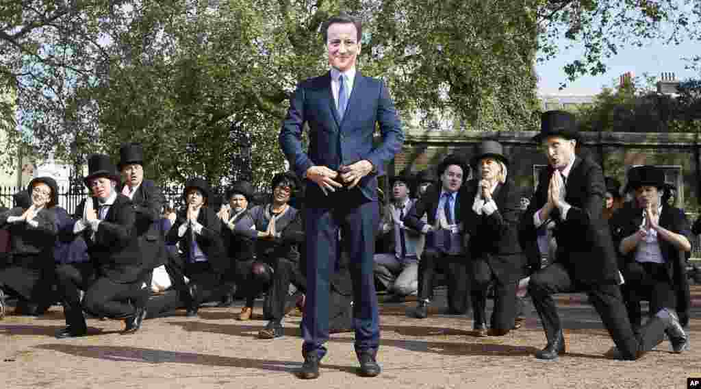 Tarian spontan &lsquo;Artful Tax Dodgers&rsquo; termasuk seorang pengunjuk rasa yang mengenakan topeng PM Inggris, David Cameron, bernyanyi dan menari di pintu masuk Lancaster House, dimana pertemuan puncak Anti Korupsi berlangsung di London.