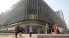 Residents walk past an Evergrande commercial complex with a shuttered Evergrande auto showroom in Beijing, Jan. 29, 2024. Chinese property developer China Evergrande Group was ordered to liquidate by a Hong Kong court, after the firm was unable to reach a restructuring deal. 