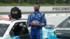 FILE - Bubba Wallace stands by his car before the start of the NASCAR Cup Series auto race at Pocono Raceway, in Long Pond, Pennsylvania, June 28, 2020.