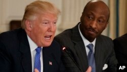 El presidente Donald Trump habla junto a Kenneth Frazier, director ejecutivo de Merck en febrero de este año. Frazier renuncio al consejo de empresas manufactureras de la Casa Blanca en protesta por la respuesta de Trump a la violencia en Charlottesville, Virginia.