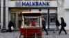 A street vendor sells roasted chestnuts in front of a branch of Halkbank in central Istanbul, Turkey, Jan. 10, 2018. 