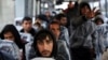 A group of migrants react as they wait to register at a processing centre in the makeshift migrant camp known as "the jungle" near Calais, northern France, Oct. 24, 2016. 