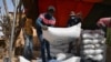 FILE - Workers carry the aid provided by the World Food Program (WFP) for distribution in Pissila, Burkina Faso, January 24, 2020.