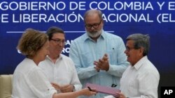 La representante del gobierno colombiano Vera Grabe, izquierda, y el comandante colombiano del grupo guerrillero ELN, Pablo Beltrán, intercambian su acuerdo de extensión del alto el fuego firmado en La Habana, Cuba, el martes 6 de febrero de 2024.