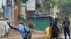 Guinean police carrying automatic weapons clear the mostly Peul suburb of Bambeto in Conakry, Guinea, Tuesday, Nov. 16, 2010, as groups of UFDG youth set up barricades. A de-facto curfew is in effect in the area, residents staying inside, one day after it