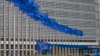 Workers adjust the EU flags in front of EU headquarters in Brussels, Belgium, June 22, 2016. 
