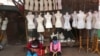 FILE - Women sit in front of mannequins at a textile market shuttered due to the coronavirus pandemic, in Jakarta, Indonesia, April 30, 2020. 