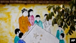 資料照片：中國西部新疆和田市團結新村一戶人家的牆上的壁畫，畫中是維吾爾族和漢族男女舉著中國國旗的場景。人權觀察曾經在2024年發表報告，指中國政府一直有系統地更改維吾爾族和其他少數民族居住的村莊名稱，以反映執政的共產黨的意識形態。