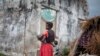 FILE - A woman holds her child at a makeshift camp for internally displaced persons (IDPs) among old abandoned buildings in Kalemie, Tanganyika province, Democratic Republic of the Congo, Sept. 18, 2017.