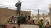  Fighters from Islamist group Ansar Dine stand guard as they prepare to publicly lash a member of the Islamic Police found guilty of adultery, in Timbuktu, Mali, Aug 31, 2012.