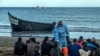 FILE- Migrants from Morocco have their temperatures checked because of the coronavirus, upon arrival at the coast of the Canary Islands, Spain, after crossing the Atlantic Ocean in a wooden boat, Oct. 20, 2020.