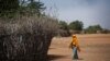 FILE - In this Dec. 19, 2017 photo, a Somali girl walks near a fence surrounding a hut at Dadaab refugee camp.