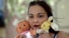 Inga Whatcott, adopted from Russia, holds two stuffed dolls she saved from her orphanage in Russia, outside her apartment in Battle Creek, Michigan, May 2013.